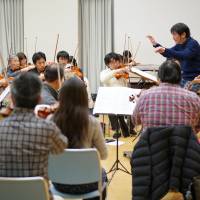 Practice makes perfect: Conductor Hisayoshi Inoue and violinist Riyo Uemura (far right) practice with the members of the amateur Mahler Festival Orchestra in Kawasaki on Jan. 29. Passion rules in Japan's amateur orchestras