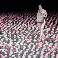 Key steps: A woman clothed in an accordion picks her way through silk carnations in “Nelken.” Bausch's legacy blossoms as emotions unfold on stage