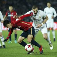 Kashima’s Shuto Yamamoto controls the ball ahead of Real Madrid’s Karim Benzema during the Club World Cup final in Yokohama on Dec. 18. Antlers enter new campaign hungry for more success