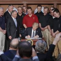 President Donald Trump signs an Energy Independence Executive Order Tuesday at EPA headquarters in Washington. Trump signed the executive order aimed at moving forward on his campaign pledge to unravel former President Barack Obama’s plan to curb global warming. Trump defies climate science, dumps Obama's clean energy plan, embraces coal