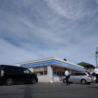 Pedestrians walk past a Lawson Inc. convenience store in Yachiyo, Chiba Prefecture. The firm has opened nine outlets with speciality services for elderly residents. Lawson offers specialized services for elderly customers