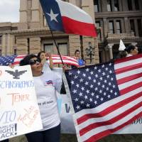 Protesters take part in a No Ban, No Wall rally to support the rights of immigrants and oppose a border wall and support sanctuary cities Tuesday at the State Capitol in Austin, Texas. U.S. economy seen as victim amid Trump push to mass-deport undocumented immigrants