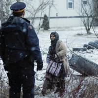 A woman who claimed to be from Syria crosses the U.S.-Canada border as a Royal Canadian Mounted Police (RCMP) officer waits to detain her in Hemmingford, Quebec, Thursday. Canada sees rise in asylum seekers crossing wintry U.S. border but says it's not expecting spring surge