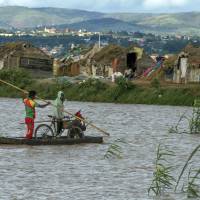 Residents of Antananarivo, Madagascar’s capital, cross flooded fields on Thursday. Powerful cyclone kills 50, affects 176,000 in Madagascar