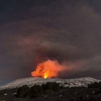 Snow-covered Mount Etna, Europe’s most active volcano, spews lava during an eruption in the early hours of Thursday. A new eruption that began on Wednesday is causing no damage to Catania’s airport, which is fully operational. Erupting Mount Etna sends molten rocks flying, hurting 10 as tourists flee down volcano