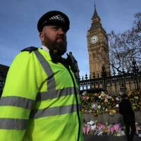 A policeman walks past floral tributes to the victims of the March 22 terror attack in front of the Elizabeth Tower, more commonly referred to as Big Ben in central London on Sunday. The British government said its security services must have access to encrypted messaging applications such as WhatsApp, revealing it was used by the killer behind the Parliament attack. U.K. arrests another man over Parliament attack, presses WhatsApp for access to killer's links