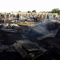 Residents of the Muna camp gather near the site of an explosion on March 22. At least four suicide bomb blasts rocked a camp for migrants fleeing Boko Haram insurgents in restive northeastern Nigeria, killing at least three people and wounding 20, officials said. Nigeria 'ransacking' areas recaptured from Boko Haram in hunt for leader