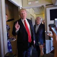 U.S. President Donald Trump speaks to reporters onboard Air Force One before departing from Palm Beach International Airport in West Palm Beach, Florida, Sunday. Trump is returning to Washington after spending the weekend at his Mar-a-Lago estate. Pressure builds on Trump to dump wiretap claim as allies try to shift focus to 'crime' of leaking Flynn's name