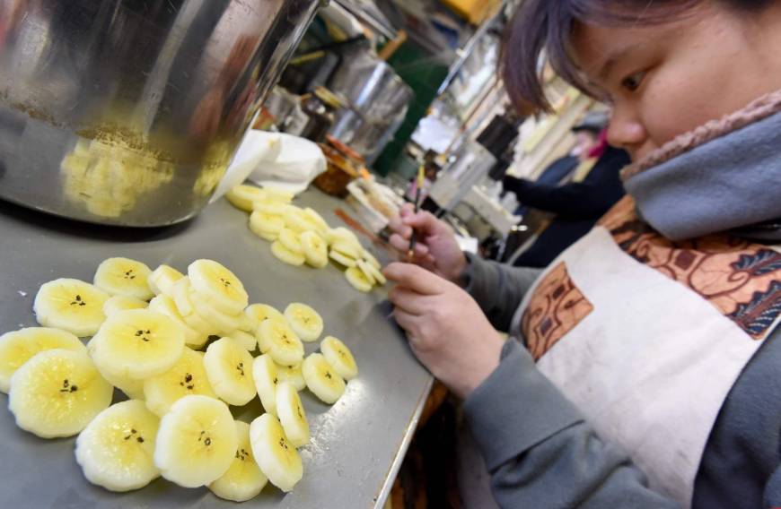 A craftswoman of Fake Food Hatanaka makes plastic banana earrings.