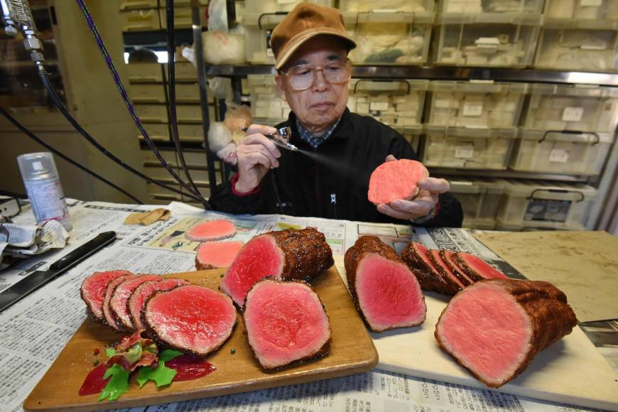 Noriyuki Mishima, a Fake Food Hatanaka craftsman, sprays paint onto plastic meat.