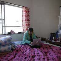 Chinese trainee Tang Xili uses a laptop computer in her room at a shelter managed by a local labor union in Hashima, Gifu Prefecture, in January last year. Japan has been heavily criticized for exploiting foreign trainees as cheap labor. In a break from LDP, Kono calls for Japan to open doors to blue-collar foreign workers
