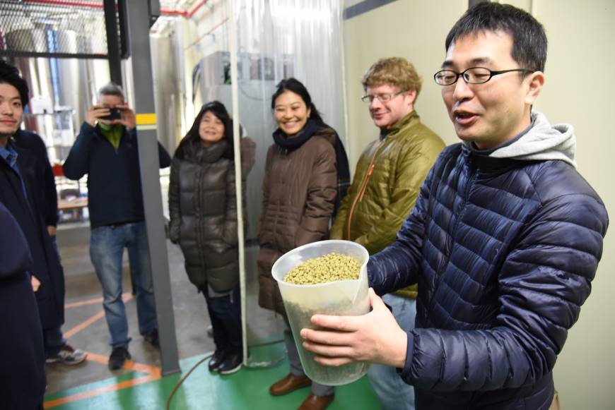 Hiroyuki Tomie, of the Japan Times beer club, holds a container of the hops, prior to them being added them to the brew kettle.