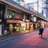 Sign of life: As daylight wanes, the lights start to come on under the train tracks in Tokyo’s Yurakucho area, where people from all walks of life rub shoulders after a hard day’s work. Culture and commerce thrive under Japan's elevated train tracks