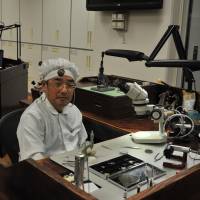 At the Shizukuishi Watch Studio, Katsuo Saito sits with a smile of pride at a customized urushi-lacquered workbench made by local manufacturer Iwayado Tansu. | CHIHO IUCHI