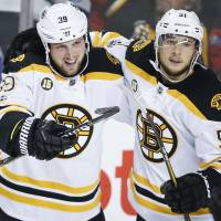 The Bruins’ Matt Beleskey (left) celebrates his third-period goal with teammate Ryan Spooner on Wednesday in Calgary. Boston defeated the Flames 5-2. Flames falter against Bruins as 10-game winning streak ends