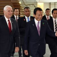 U.S. Vice President Mike Pence is escorted by Deputy Prime Minister Taro Aso as they walk to their meeting with Prime Minister Shinzo Abe in Tokyo on Tuesday. Japan Inc. warily welcomes new economic dialogue with U.S.