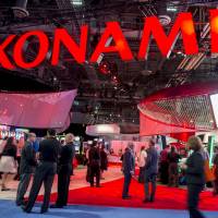 Attendees walk past the Konami Holdings Corp. booth during the 2016 Global Gaming Expo in Las Vegas last September. Slot machine-maker Konami says Japan casinos will need Vegas-style oversight