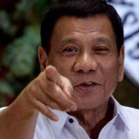 Philippine President Rodrigo Duterte points to photographers during an awards ceremony for outstanding government workers held at Malacanang Palace in Manila in December. Lawyer for Philippines hit man files complaint against Duterte in international court