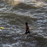 An Indian boy walks along a flooded bank of the Ganges River in Allahabad on July 10, 2016. Himalayan glaciers granted status of 'living entities'