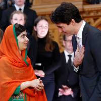 Canadian Prime Minister Justin Trudeau gestures toward Pakistani Nobel Peace Prize laureate Malala Yousafzai after presenting her with honorary Canadian citizenship during a ceremony in the Library of Parliament on Parliament Hill in Ottawa Wednesday. Malala Yousafzai becomes only sixth to receive honorary Canadian citizenship