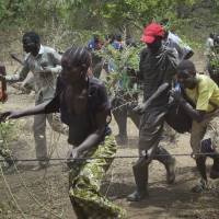 South Sudanese refugees run toward a supply distribution point after they arrived at their resettlement area at the Imvepi Camp in Northern Uganda Tuesday. Thousands keep on crossing into Uganda as civil war continues across the border in South Sudan, and the surge of more than half a million South Sudanese refugees into Uganda since July has created Africa’s largest refugee crisis. South Sudan survivors who fled to Uganda recount slaughter at hands of troops