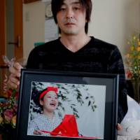 Go Kasai, father of Rima Kasai who killed herself, poses with his daughter’s picture at his house during an interview in Fujisaki, Aomori Prefecture, in February. Bullying in schools keeps youth suicide rate high