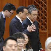 Chinese Premier Li Keqiang (center) talks to Yohei Kono, head of the Japanese Association for the Promotion of International Trade, before their meeting Monday at the Great Hall of People in Beijing. Chinese premier positive on improving relations with Japan