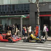 People dressed in Nintendo video game characters drive go-karts in Tokyo on April 2. Go-kart firm seeks to dismiss Nintendo suit over 'Mario Kart' copyright