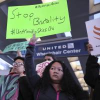 Members of Asian community organizations demonstrate against United Airlines at Chicago’s O’Hare airport on Tuesday. JAL and ANA say overbooking violence would never happen in Japan