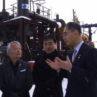 Politics of power: Hiroyuki Kawai (left) and Tetsunari Iida (center) discuss the economics of renewables with a banker in front of a geothermal apparatus in the town of Tsuchiyu Onsen in Fukushima Prefecture. Documentary renews debate over renewable energy