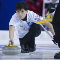 Japan skip Yusuke Morozumi makes a shot during the seventh end against Sweden at the Men’s World Curling Championships in Edmonton, Alberta, on Monday. Japan men split pair of matches at curling worlds