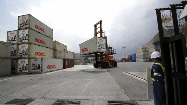 A security guard stands at the entrance of a transport container terminal in Tokyo. Japan posted a trade surplus for the third straight month in April, according to data released Monday. Exports propel Japan to third straight monthly trade surplus