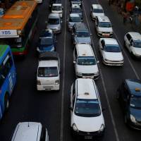 City taxis are seen amid traffic in central Yangon in Myanmar Thursday. Uber chases GrabTaxi in Myanmar, tapping into one of world's fastest-growing markets