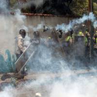 Riot police crack down on students at the Central University of Venezuela during clashes in a protest against the government of Nicolas Maduro in Caracas on Thursday. Anti-government protests raged on as students launched fresh marches after a day of flames and tear gas brought the death toll to 33. Venezuela descends further into deadly unrest as students rally, attorney general quits