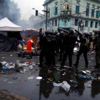 Riot police take position during a police operation in a neighborhood known to locals as Cracolandia (Crackland), in downtown Sao Paulo, Brazil, Sunday. Sao Paulo police en masse make sweep through city's 'crackland' in bid to bust up drug trade