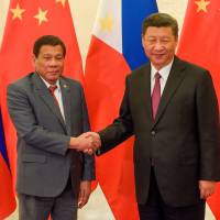 Chinese President Xi Jinping shakes hands with Philippines leader Rodrigo Duterte prior to their bilateral meeting during the “Belt and Road” summit, at the Great Hall of the People in Beijing on Monday. Philippines' Duterte says he is open to South China Sea deals with Beijing