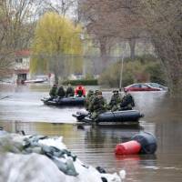 Canadian soldiers guide their boats through a flooded residential area in Gatineau, Quebec, Tuesday. Over 2,000 flee as Saint Lawrence, other rivers burst banks in Quebec