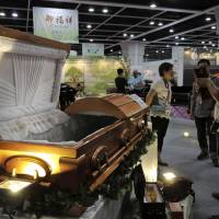 Visitors look at a paper casket at the Asia Funeral and Cemetery Expo & Conference in Hong Kong on Thursday. Asian funerals go green, high-tech at Hong Kong trade fair