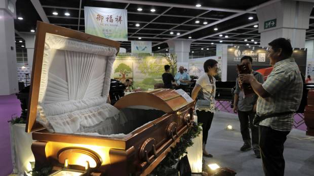 Visitors look at a paper casket at the Asia Funeral and Cemetery Expo & Conference in Hong Kong on Thursday. Asian funerals go green, high-tech at Hong Kong trade fair
