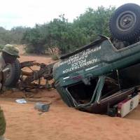A picture taken with a mobile photo Thursday shows a policeman looking at the wreckage of a police vehicle following a roadside bomb in Garissa, northeastern Kenya. Five police officers were killed when their vehicle hit the roadside bomb in northeastern Kenya, a day after two separate IEDs killed eight officers, a regional security official said. Al-Shabab IED kills five more Kenyan police in third such bombing