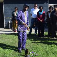 Dr. Thomas J. Durant Jr. (center), professor emeritus of African-American Studies at Louisiana State University, performs a libation ceremony on the grounds of American Legion Raymond Stafford Post 513 in Thibodaux, Loouisiana, in February. Victims of the 1887 Thibodaux Massacre are believed buried in a mass grave at the site. This memorial, conducted in conjunction with the River Road African-American Museum in Donaldsonville, is one of several commemorations held since publication of “The Thibodaux Massacre: Racial Violence and the 1887 Sugar Cane Labor Strike” by John DeSantis. Kin of 1887 racial Thibodaux Massacre honor victims, hunt for graves of up to 60