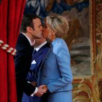 French President Emmanuel Macron kisses his wife, Brigitte, during the handover ceremony in Paris on Sunday. No taboos at Elysee as Mrs. Macron signals change