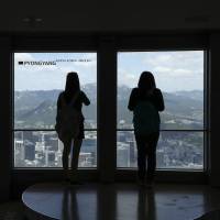 Visitors tour near the window with a sign “Pyongyang” at the N Seoul Tower in Seoul on Friday. Seoul lets NGO contact North Korea to discuss renewed cooperation