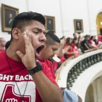 Pedro Paredes joins hundreds of protesters lining the balconies of the state Capitol rotunda in Austin, Texas, on Monday, the last day of the legislative session, to protest Senate Bill 4, legislation already passed by Texas Gov. Greg Abbott that compels local police to enforce federal immigration law. 'Sanctuary city' advocates drown out Texas lawmakers, spark scuffle on House floor