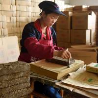A worker packages bricks of tea leaves for export on Thursday in Wuyi, in China’s eastern Zhejiang province. Xi bets on Silk Road forum to boost stature