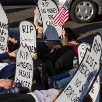 Protesters staging a “die-in” before a town hall meeting with US Representative Tom MacArthur in Willingboro, New Jersey, on May 10. Under U.S. Republican bill, 23 million people would lose health coverage, Congressional Budget Office says