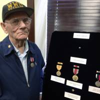 World War II veteran Joseph Aquilante, 91, of North Providence, Rhode Island, stands beside medals presented to him by U.S. Sen. Jack Reed Monday at the senator’s office in Cranston. quilante, of North Providence, sought the medals so he could leave them for his grandchildren and great-grandchildren. He says he wants to pass them on as a keepsake and part of history. Pacific WWII, Occupation vet, 91, receives overdue medals in Rhode Island