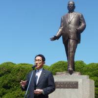 Foreign Minister Fumio Kishida, head of the LDP’s Kochi Kai faction, speaks in front of the statue of former Prime Minister Hayato Ikeda on Sunday in the city of Hiroshima. Kishida eyes prime ministership as LDP's Kochi Kai faction celebrates 60th anniversary