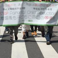 A group of about 30 parents whose children were abducted by spouses take part in a demonstration in Taito Ward, Tokyo, on Friday, to lobby for the inclusion of joint custody rights in the Japanese legal system. Parental abduction victims hold rally to push for joint custody rights