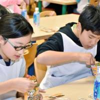 Students eat emergency food at an elementary school in Otari, Nagano Prefecture. Japan's regional governments overwhelmed by emergency food nearing expiration dates
